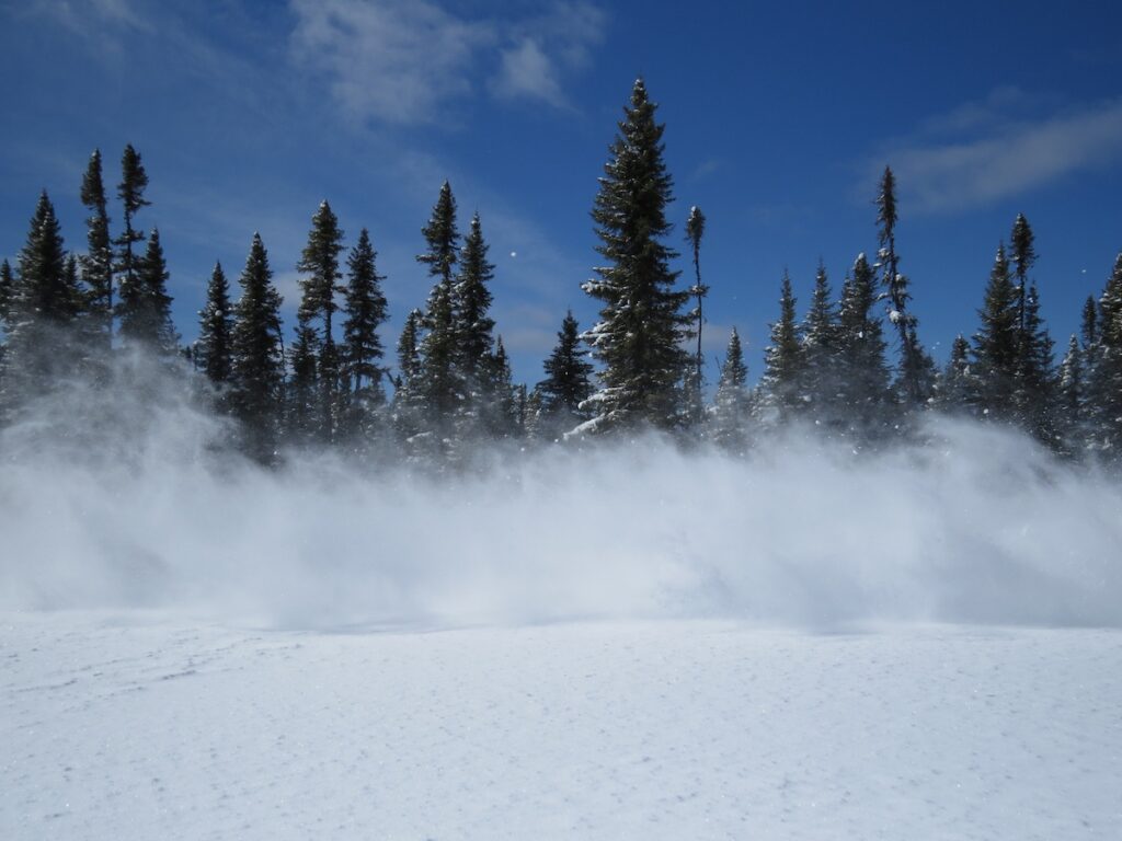 snow dust generated by a passing snowmobile