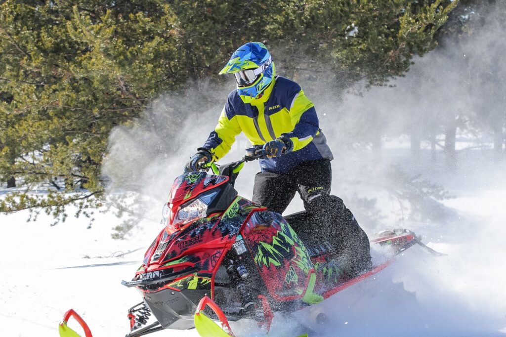 Ski Doo snowmobiler playing in powder