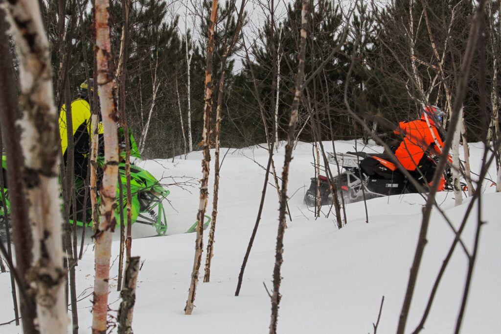 side view of 2 snowmobiles