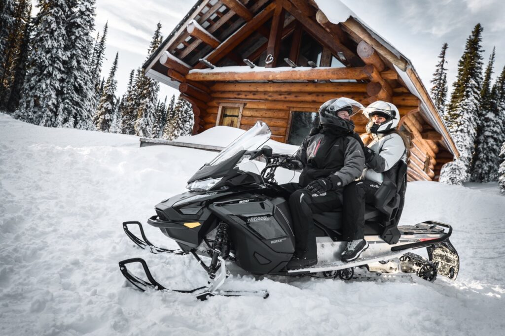 Couple talking with oxygen snowmobile helmets on