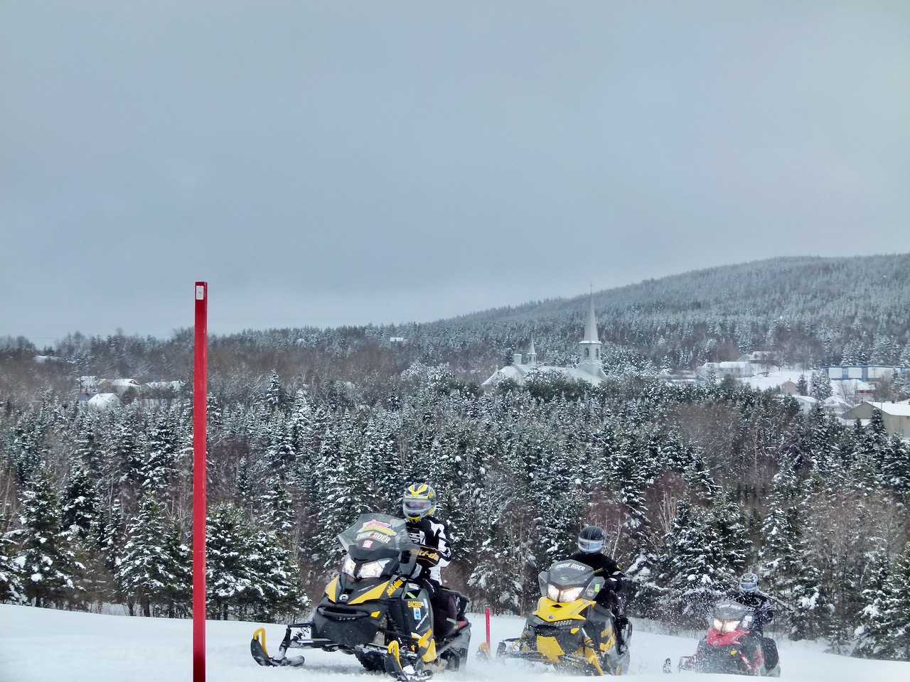 Staked snowmobile trail near a village in the Centre-du-Quebec Region.