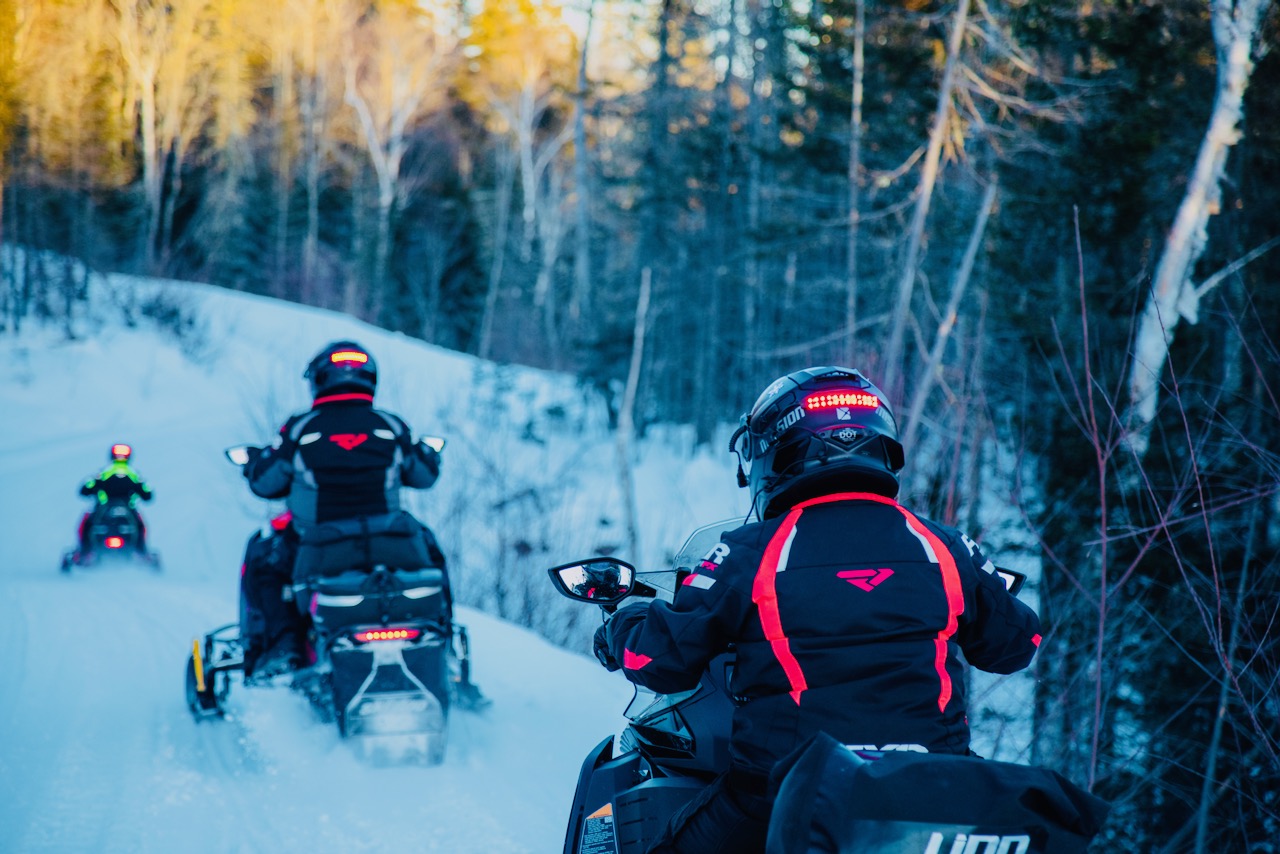 Riding with snowmobiling accessory essentials like Helmet Safety Lights at dusk.